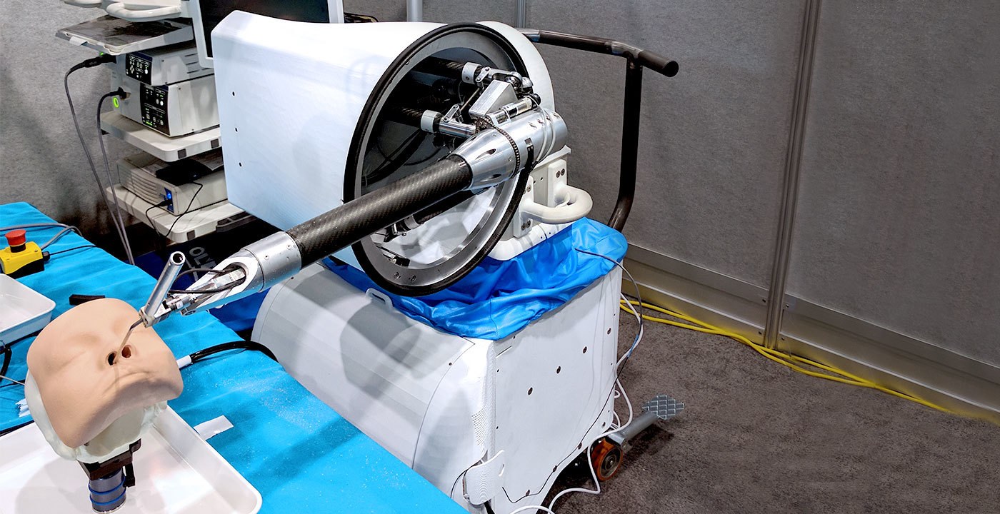 Galen surgical robot positioning an instrument beside a training mannequin’s nose.