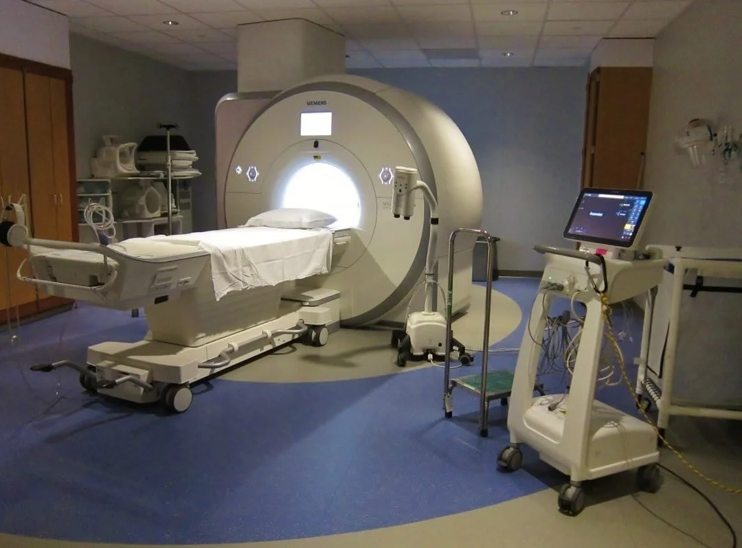 Siemens MRI scanner, patient table, and monitoring equipment in a UMMC imaging room.